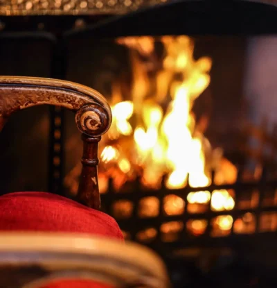 red chair sitting by the real log fire in the lounge at Fischer's