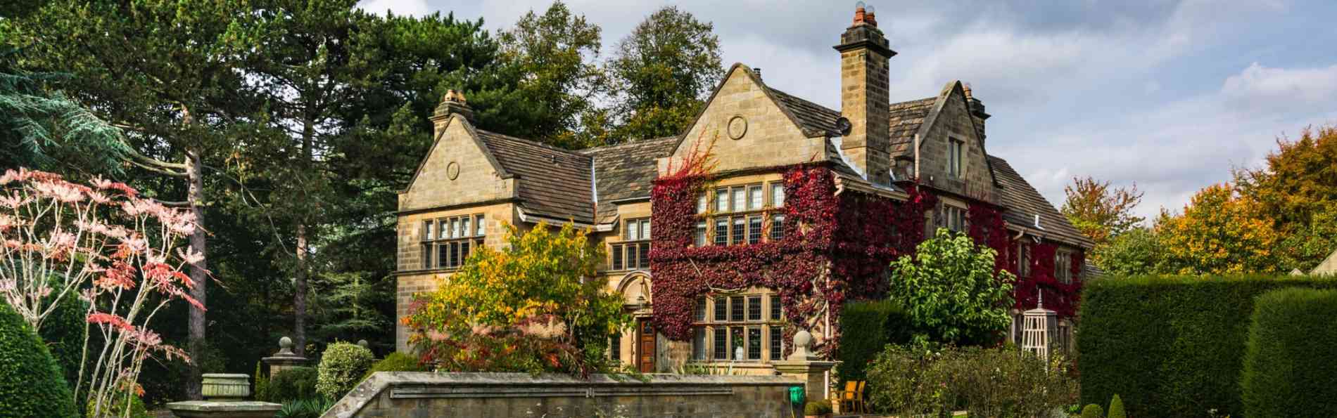 Abeautiful manor house set within beautiful autumn grounds with rich red ivy