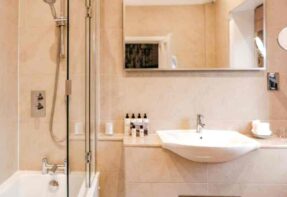 modern bathroom with a shower over a bath, large white sink and mirror ?>